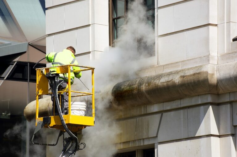 Ein Arbeiter reinigt die Fassade.